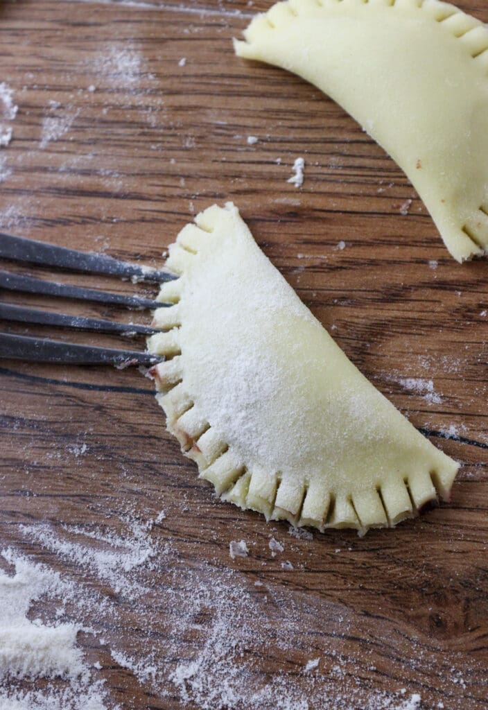 Hom to use the fork to close the edges of the cookies so they don't open while baking